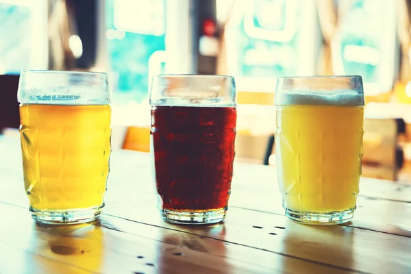 Beer on a wooden bar counter in pub — Stock Photo, Image