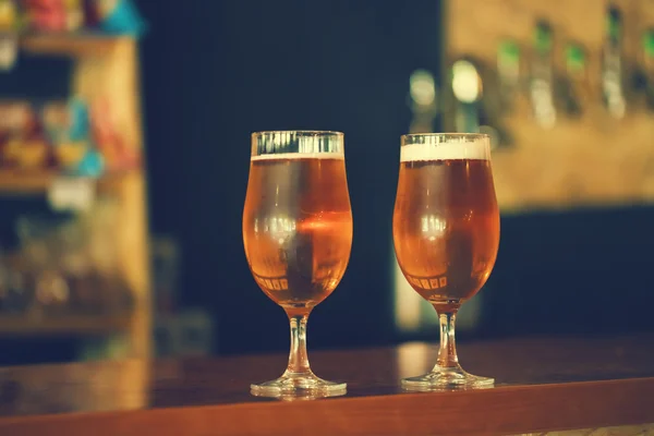 beer on a wooden bar counter in pub