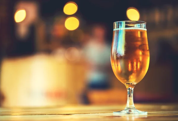 Cerveja em um balcão de madeira bar no pub — Fotografia de Stock