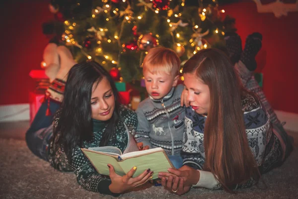 Mladá rodina u vánočního stromu — Stock fotografie