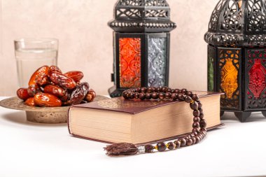 Ramazan ayının Müslüman bayramı. Parlak fener, kurumuş hurma, dua boncukları ve Kuran kitabıyla güzel bir arkaplan.