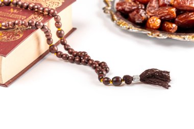Ramazan ayının Müslüman bayramı. Kurumuş tarihler, dua boncukları ve Kuran kitabıyla güzel bir arkaplan.