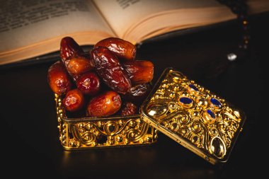 Açık bir Müslüman kutsal Kur 'an' ı ile kurutulmuş tarihler. Kutsal Ramazan ayının Müslüman bayramı Kerim arka planda