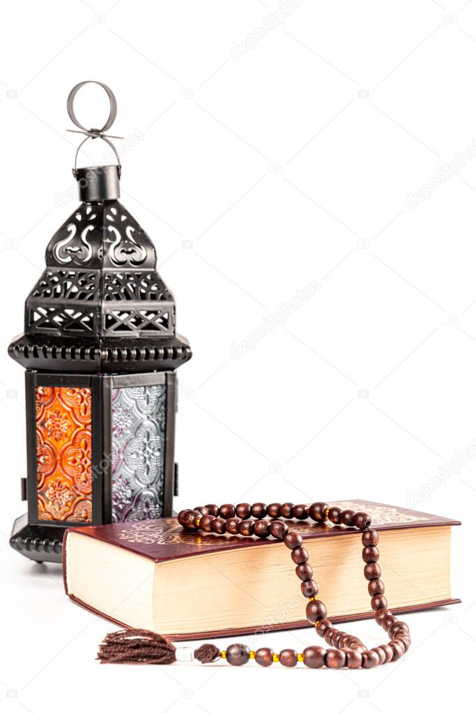 Muslim holiday of the holy month of Ramadan Kareem. Beautiful background with religious book quran, prayer beads and arabic lantern on white