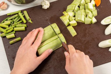 Ahşap tahtada kabak kesen kadın ellerinin yakın çekimi.