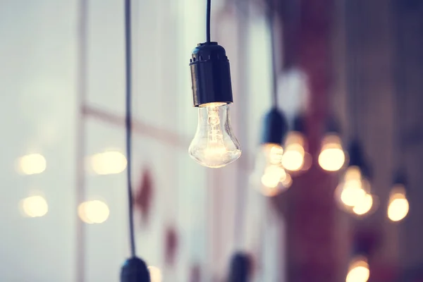 Light bulbs hanging at window — Stock Photo, Image