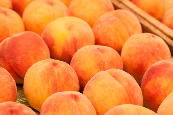 Färska persikor i trä korg — Stockfoto