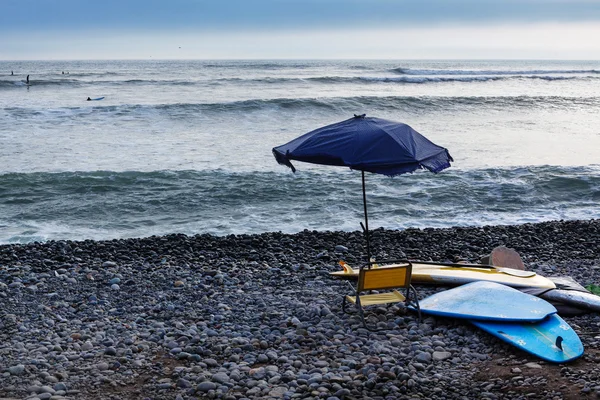 Pranchas de surf e guarda-chuva de praia — Fotografia de Stock