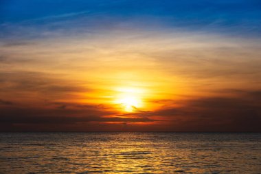 Okyanusun üzerinde bulutlarla dramatik gün batımı