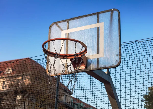Basketball basket on the street against the blue sky