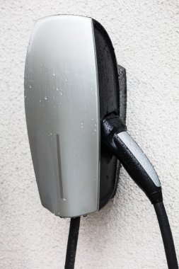 beyaz bir duvarda bir elektrikli araba şarj istasyonu