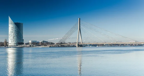 Een weergave van de gebouwen en de Vansu brug aan de oevers van de rivier de Daugava in Riga, Letland — Stockfoto