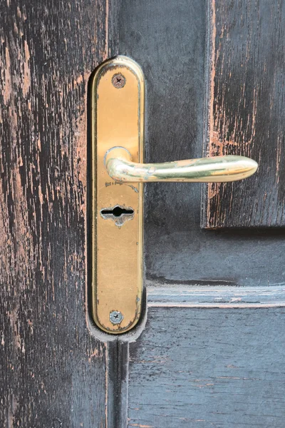 Maniglia porta dorata su vecchia porta in legno intemperie — Foto Stock