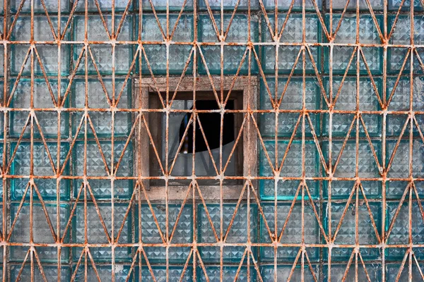 Skleněných tvárnic staré okno pokryté rezavě mřížky pro stavební konstrukce — Stock fotografie