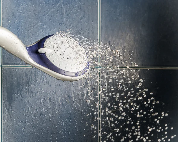 Shower head with water drops levitate about and place for text — Stock Photo, Image