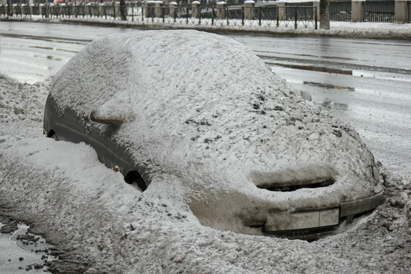 Coche cubierto de nieve en la calle — Foto de Stock