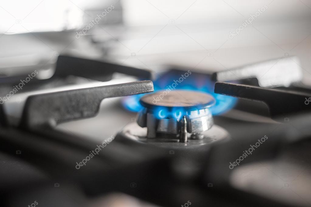 Blue flames of gas burning from a kitchen gas stove. Selective focus.