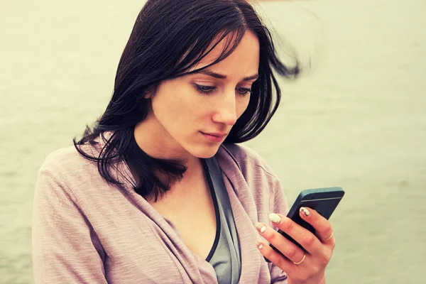 Mulher jovem mensagens de texto no celular — Fotografia de Stock