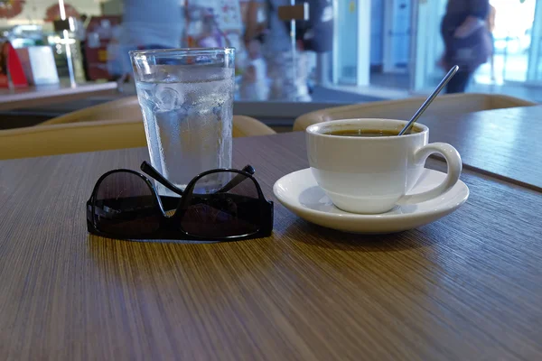 Kaffee und Sonnenbrille auf dem Tisch — Stockfoto