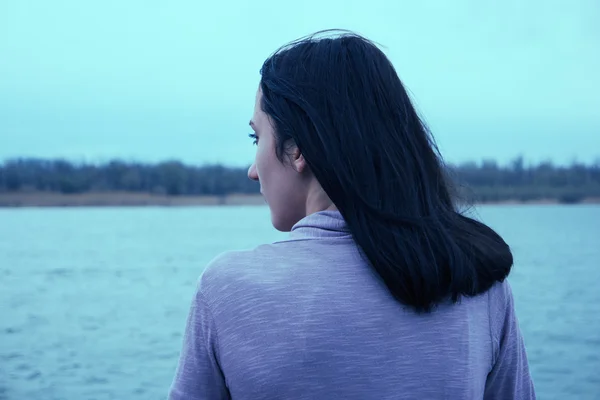 Молодая женщина смотрит на реку — стоковое фото