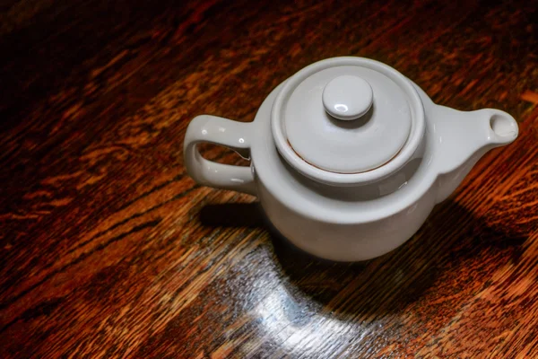 White teapot top view on vintage wooden table — Stock Photo, Image