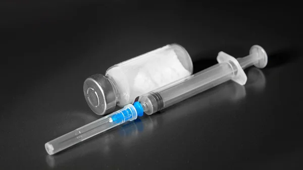 Spritze mit Nadel und Fläschchen auf schwarzem Hintergrund, injektionsfertig — Stockfoto