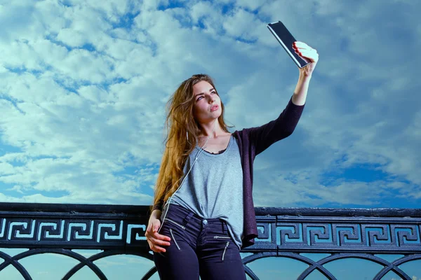 Les jeunes femmes beautyful utilisent phablet pour la photographie selfie dans la journée brillante contre ciel nuageux — Photo