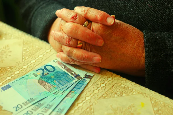 Vieille femme avec 20 euros de billets sur la table — Photo
