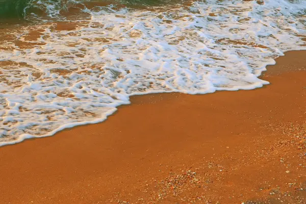 Våg av havet på sandstranden bakgrunden med en massa copyspace — Stockfoto