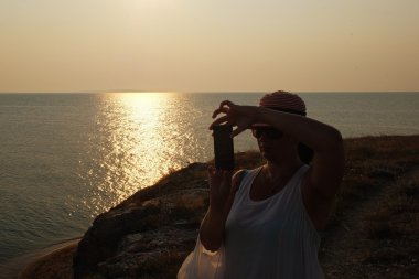 Woman doing selfie on the sea coast