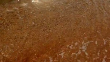 Kumlu plaj şeffaf sığ su denizde dalga yumuşak
