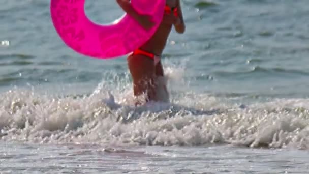 Жінка ходить по хвилях пляжу в прекрасний день невпізнавані люди — стокове відео