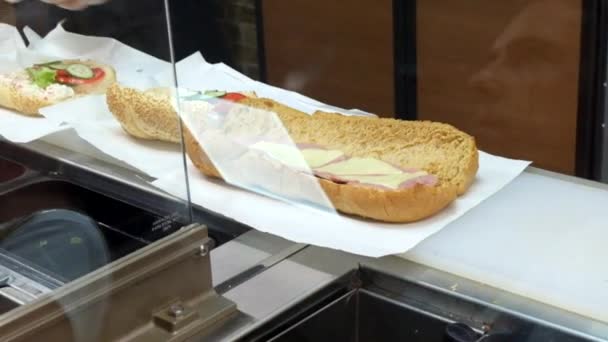 Lose up of a woman preparing a baguette lunch sandwich with fresh vegetables — Stock Video