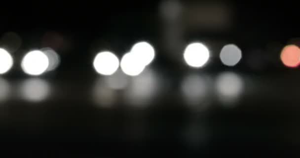 Luzes de bokeh desfocadas desfocadas na estrada da cidade durante a noite. Tráfego desfocado na cidade . — Vídeo de Stock