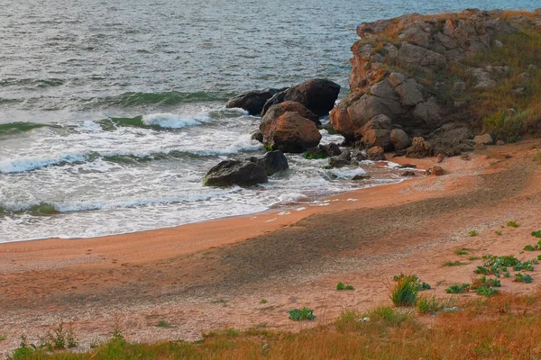 Пісок і скелі тропічного моря, хвилі з піною на його вершинах — стокове фото