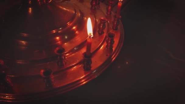 Lonely candle is burning on golden candle stand in orthodo church — Stock Video