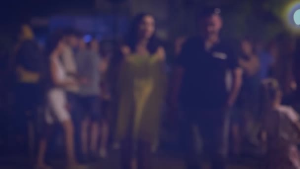 Pár se večer drží za ruce na přeplněné ulici. — Stock video