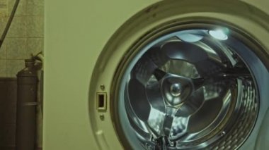 Eski çamaşırhanenin kapısını açıp içeri girmek.