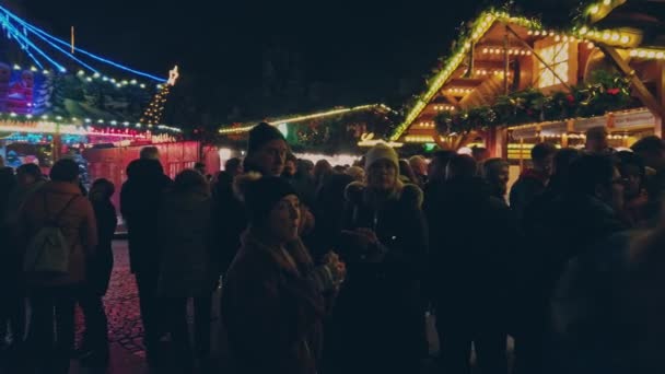 Bonn Germany, 23 Desember 2019: Penonton Natal. Orang-orang berjalan di sepanjang warung-warung di pasar Natal gerakan lambat 4k — Stok Video