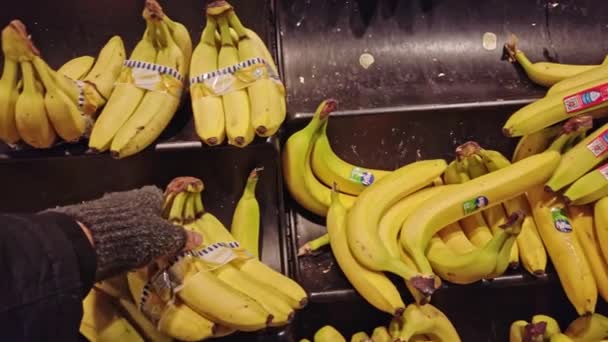 Bonn, Alemanha - 14 de dezembro de 2019: O homem escolhe a banana no shopping e coloca-a no backet — Vídeo de Stock