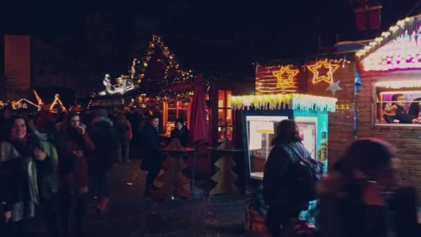 Bonn Alemania, 23 dic 2019: Noche de mercado navideña. Mucha gente va en cámara lenta. — Vídeo de stock