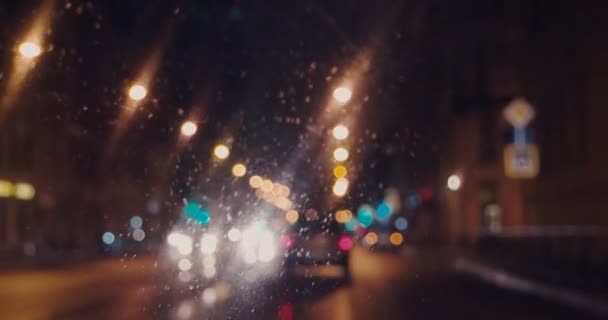Yağmurlu bir gecede araba sürmek bulanık görüntüler, ıslak yol yüzeyindeki arabanın içi yansımalarla dolu. — Stok video