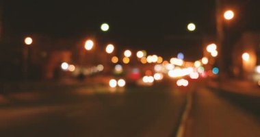Şehirde gece trafiği. Hareket halindeki arabalardan gelen bulanık ışıklar.