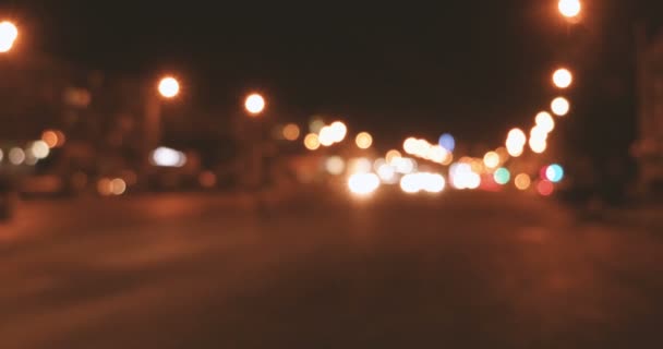 Bytrafikk i mørket. Flere uskarpe lykter fra biler i bevegelse – stockvideo