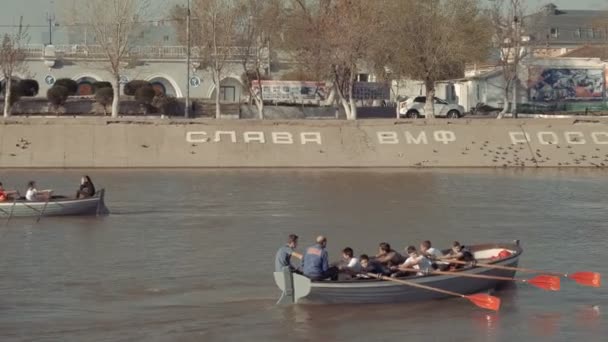 Astrakhan, Rusko, 27. dubna 2018: Dva skauti veslaři na vodě. Dřevěné veslice veslařské vody. — Stock video