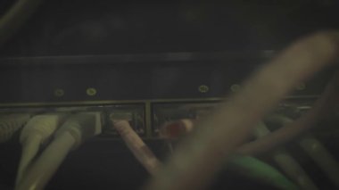 Yanıp sönen ışıkları olan sunucu ya da Commutator. IP geçitleri. Küçük veri merkezindeki bir rafta bilgisayar kırıyor. Bağlı Sunucuyu birçok yıpranmış kabloyla kapat.