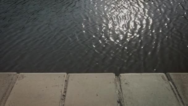 Vista al agua con pequeñas olas sobre el parapeto de hormigón — Vídeos de Stock