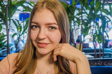 Sarışın kadın yüzü, tropik saksı bitkilerinin arka planında.