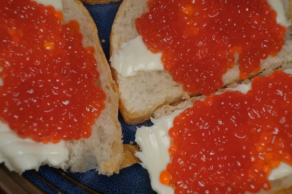 Red fish eggs on butter sandwiches top view. Traditional russian delicatessen.