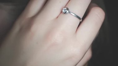 Kafkasyalı genç bir kadının kulağı. Kulağını açtı. Elinde bir çıngırak yüzüğüyle.